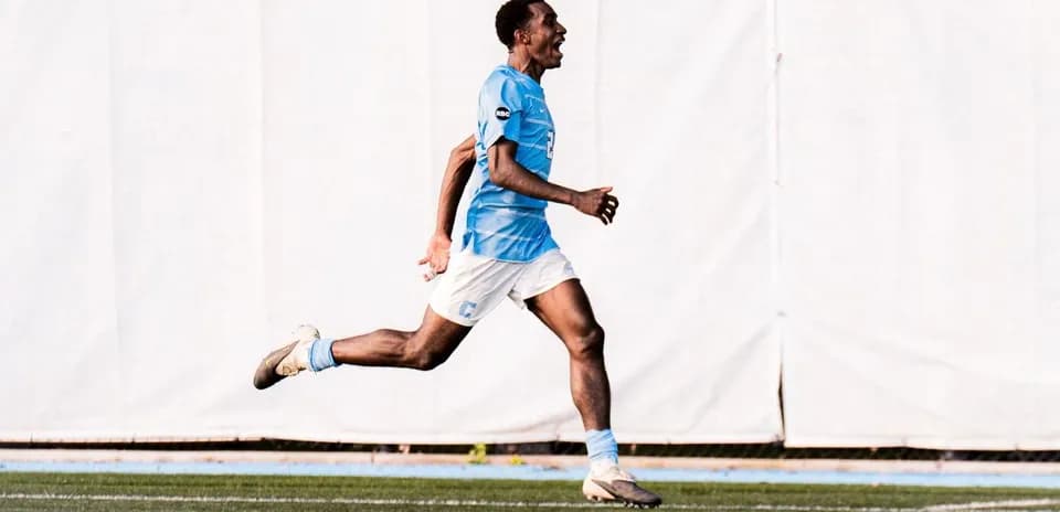Player celebrating while running on soccer field