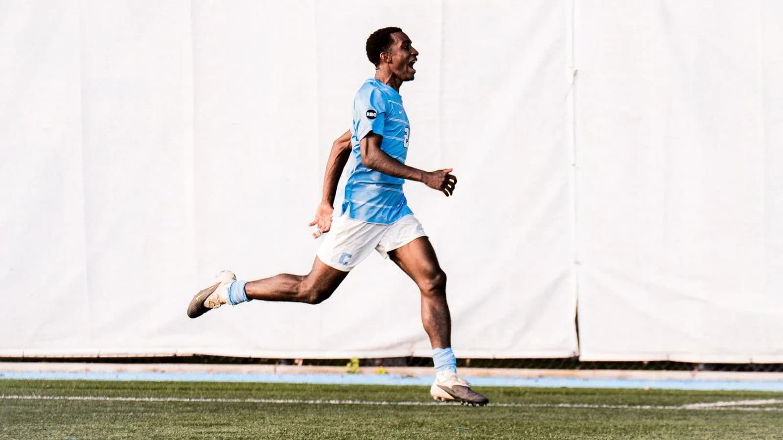 Player celebrating while running on soccer field