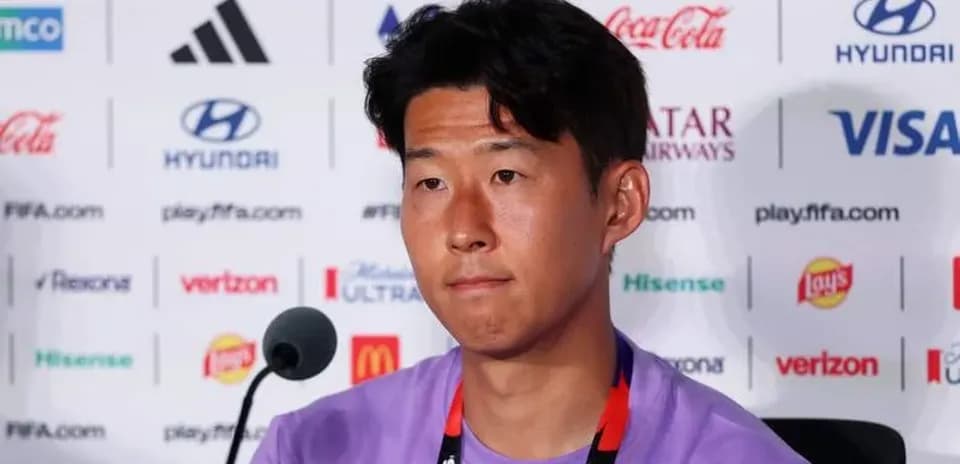 Player at press conference with sponsor logos in background