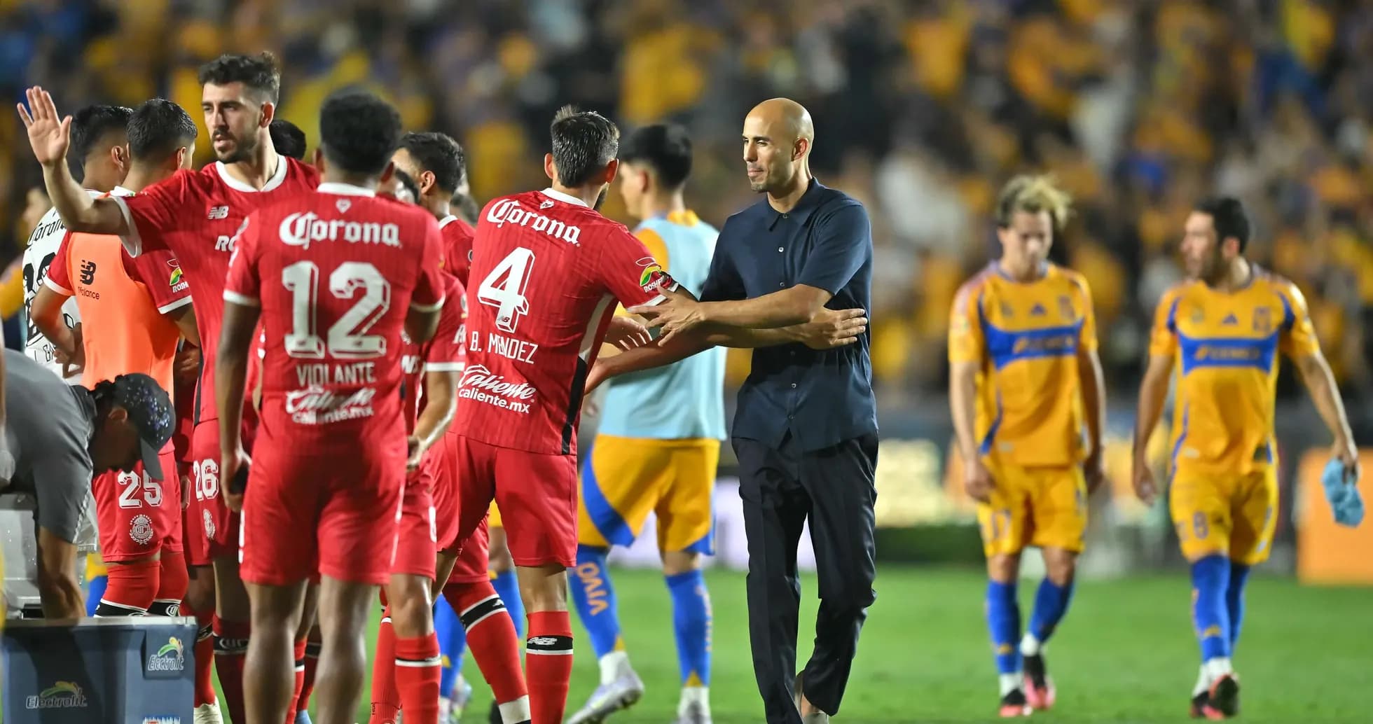Toluca players congratulating coach after match