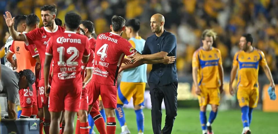 Toluca players congratulating coach after match