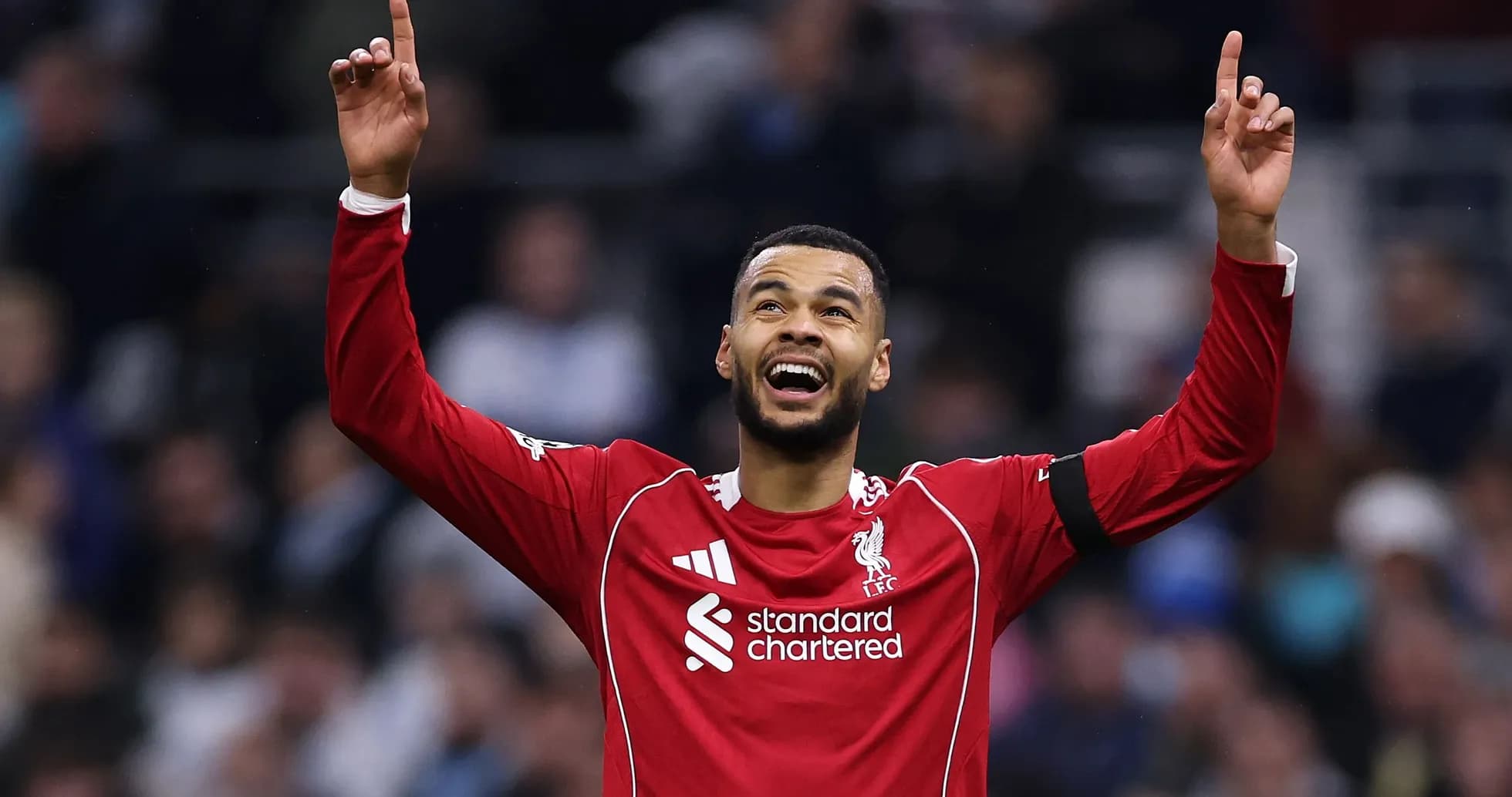 Player celebrating with raised arms in Liverpool kit