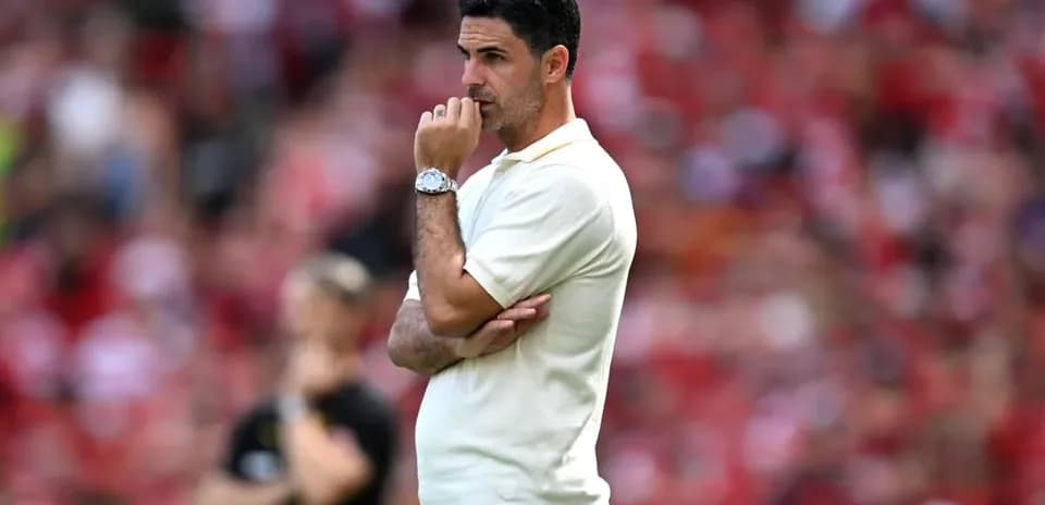 Manager observing match with arms crossed on sidelines