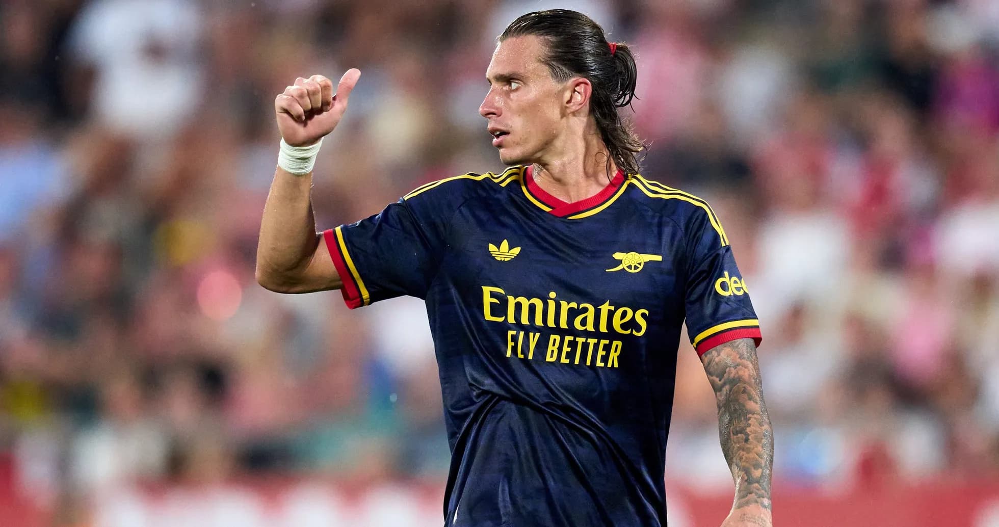 Player gesturing during match wearing Arsenal jersey