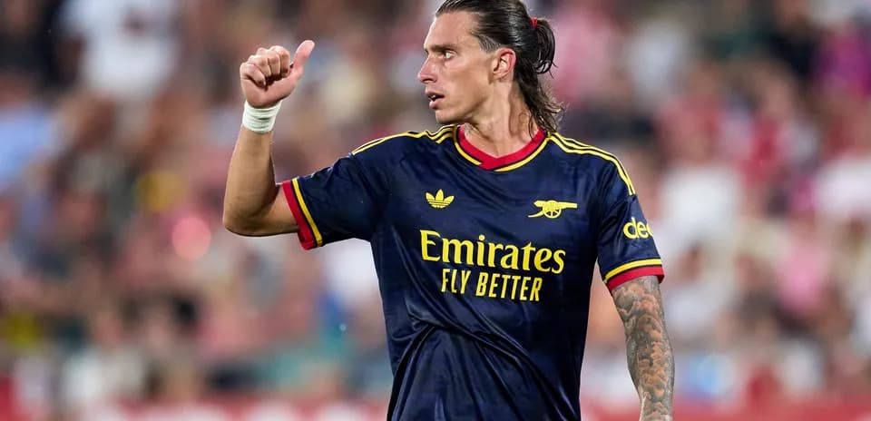 Player gesturing during match wearing Arsenal jersey