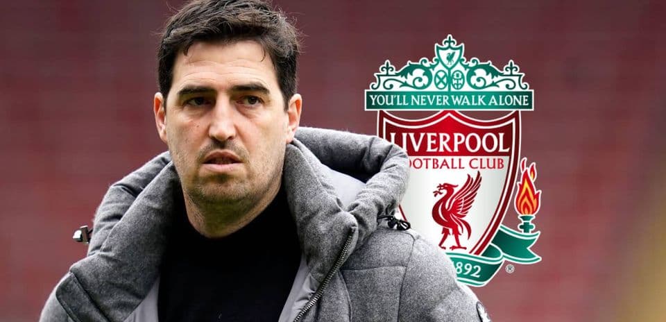 Coach standing in front of Liverpool FC logo