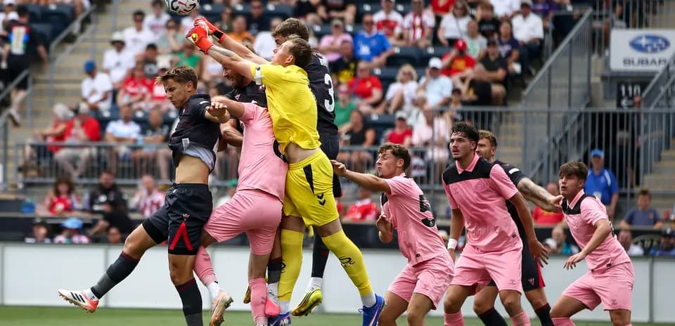 Goalkeeper jumping to catch the ball amidst players