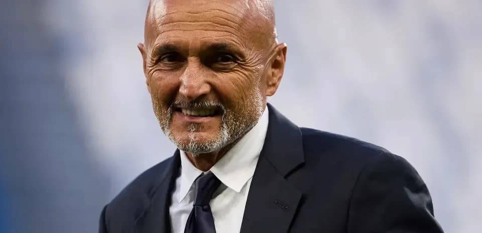 Coach smiling in formal suit at stadium