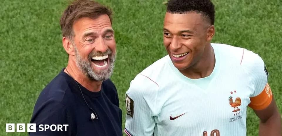 Manager and player smiling on the pitch