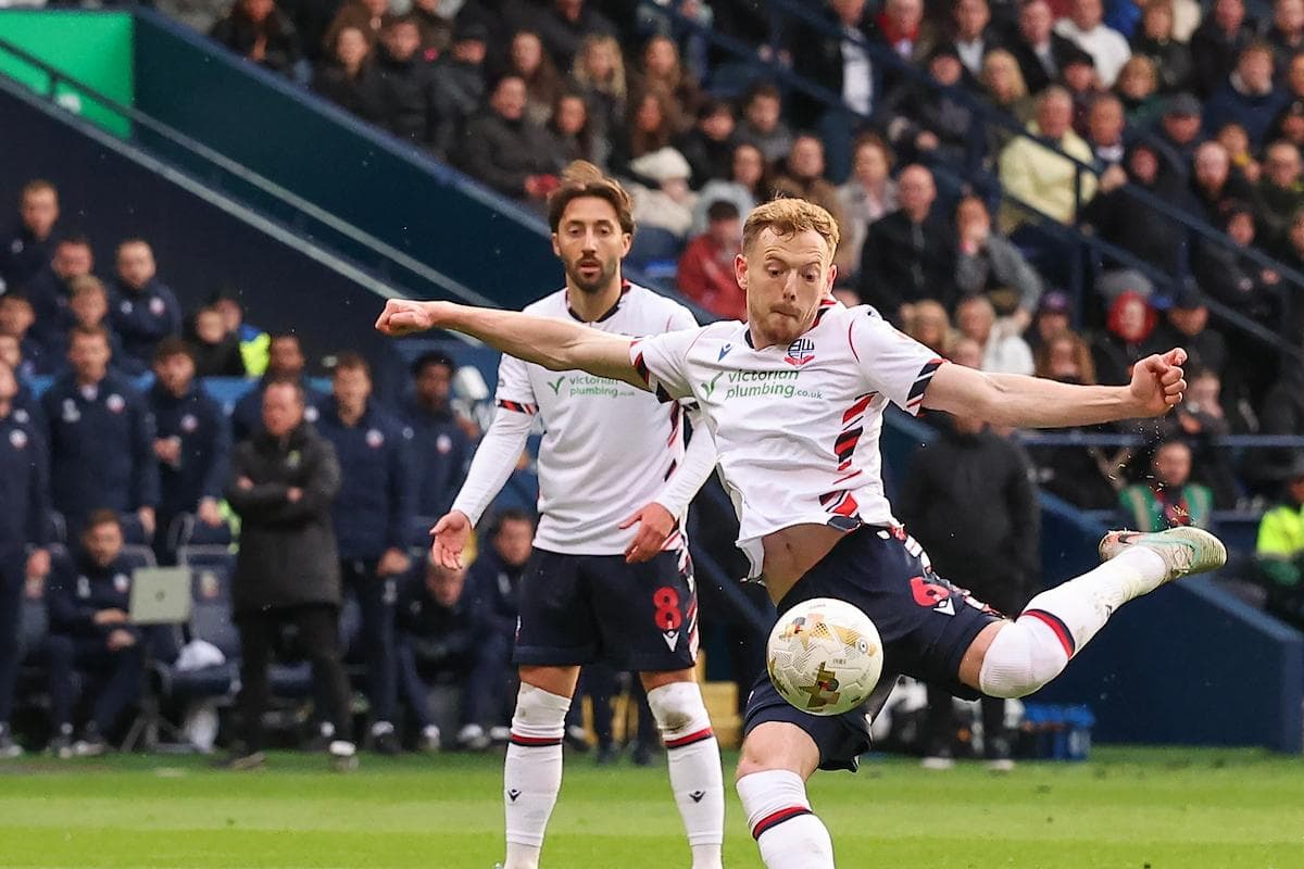 Bolton player kicking ball during match action
