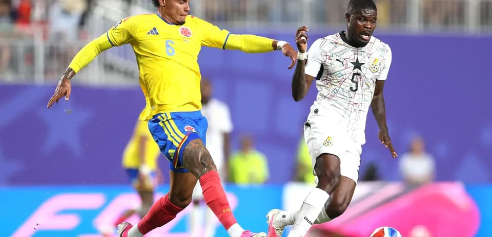 Colombian player challenging Ghanaian opponent during match