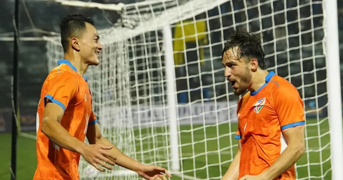 Players celebrating a goal in orange jerseys