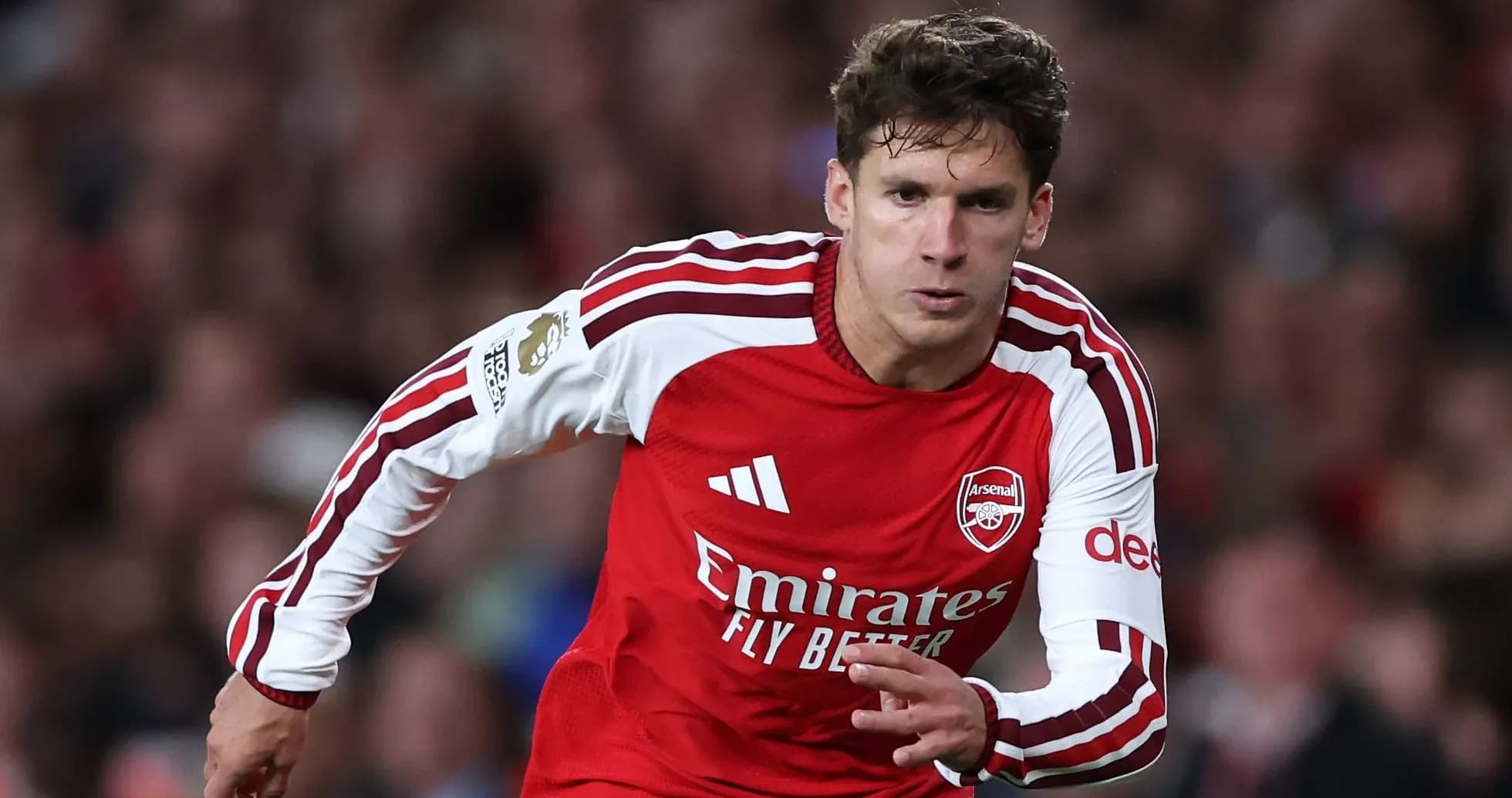 Player in red Arsenal kit running on the pitch