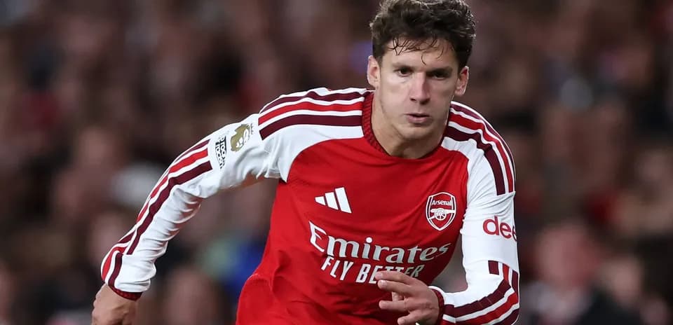 Player in red Arsenal kit running on the pitch