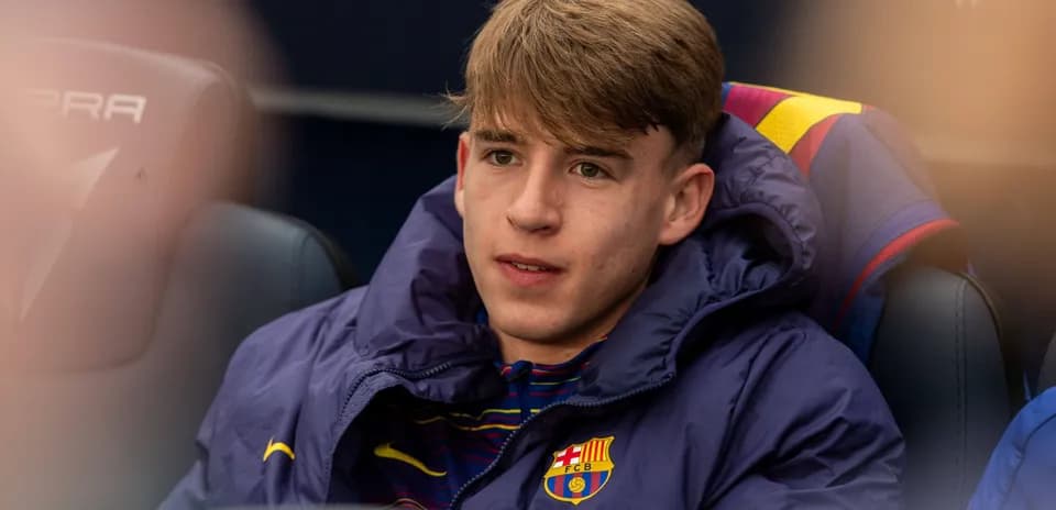 Player sitting on bench in Barcelona jacket