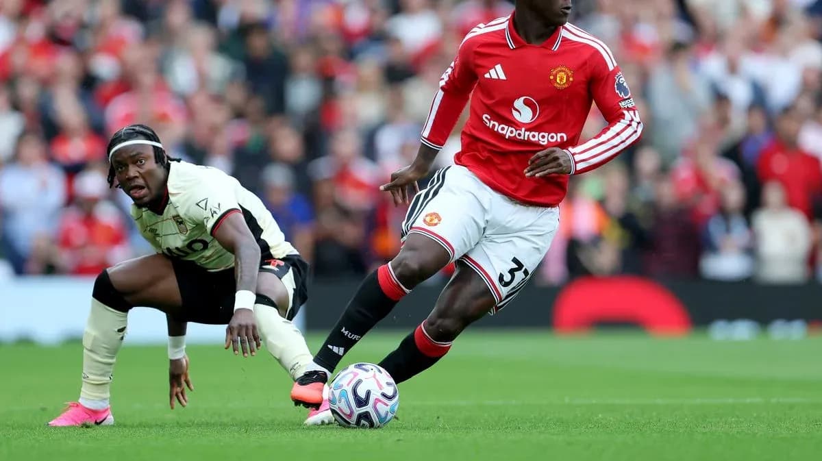 Manchester United player dribbling past opponent during match