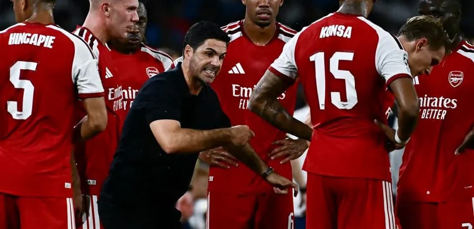 Arsenal players gathered around manager during strategy discussion