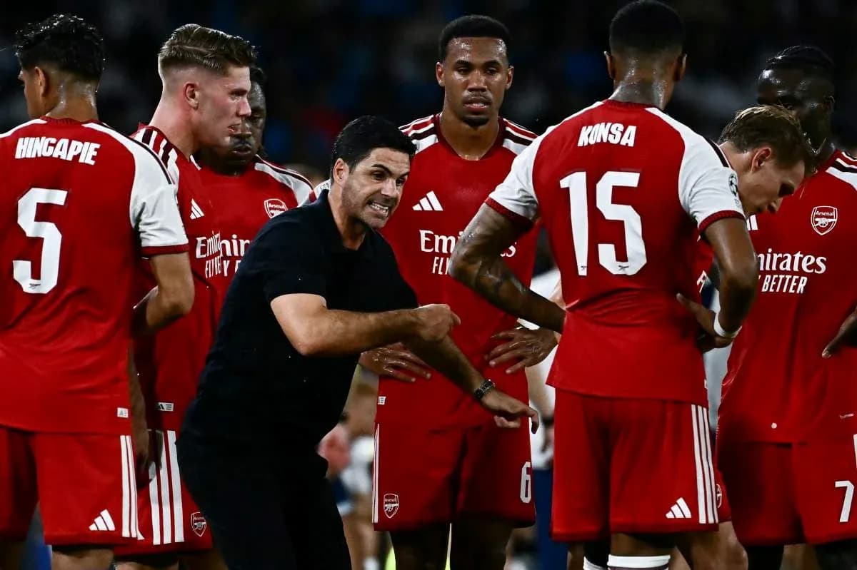 Arsenal players gathered around manager during strategy discussion