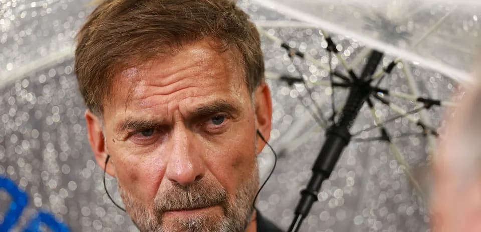 Man with umbrella during a rainy press conference