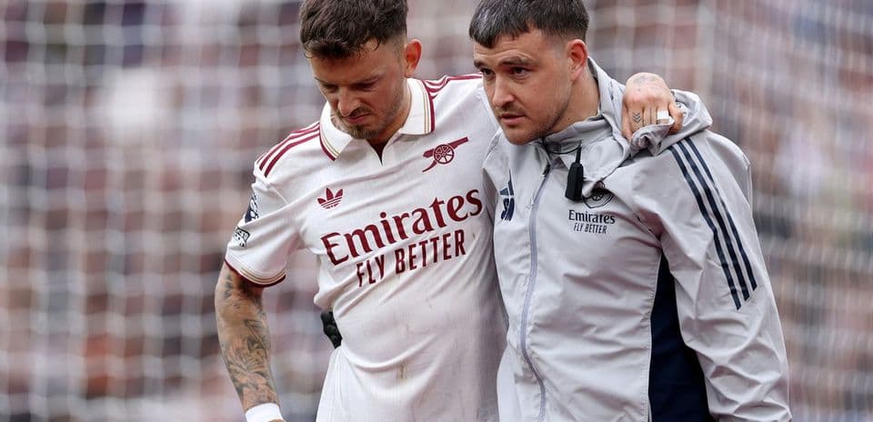 Player being assisted off the field by staff