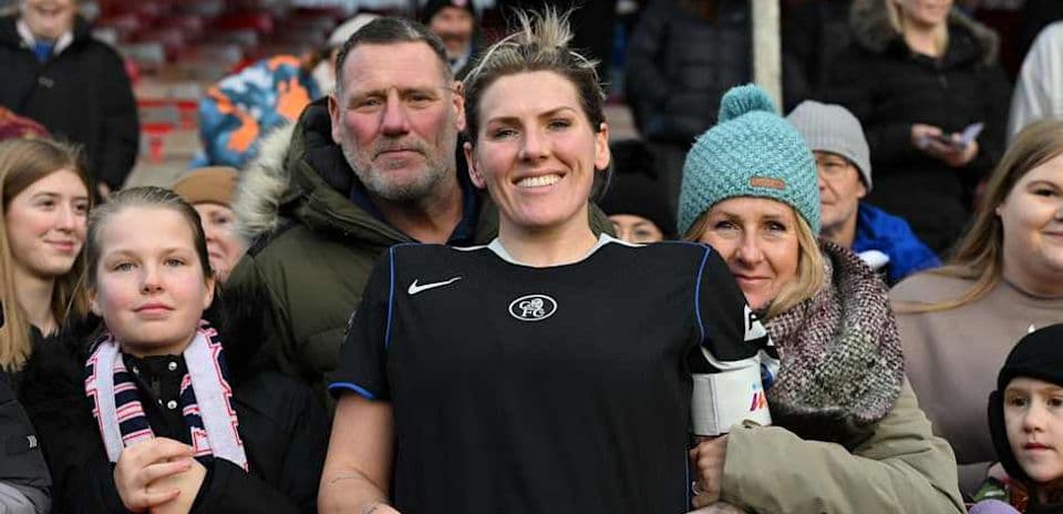 Football player smiling with fans at the stadium