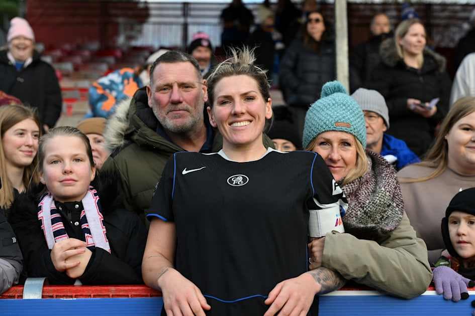 Football player smiling with fans at the stadium