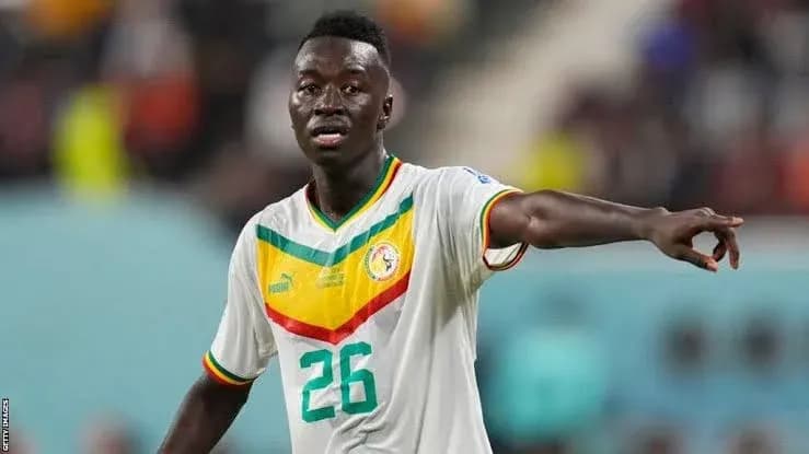 Player in Senegal national team kit directing teammates