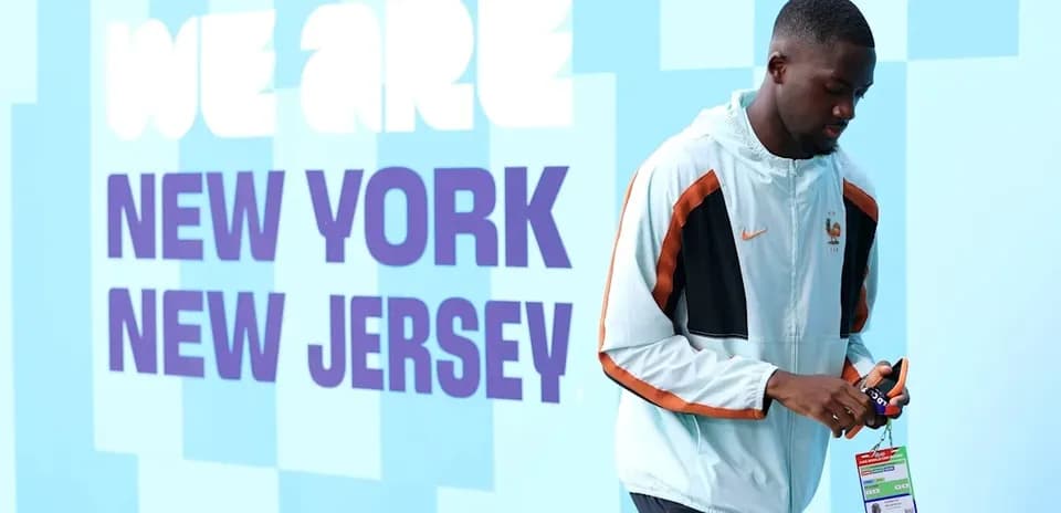 Player walking by 'We Are New York New Jersey' sign