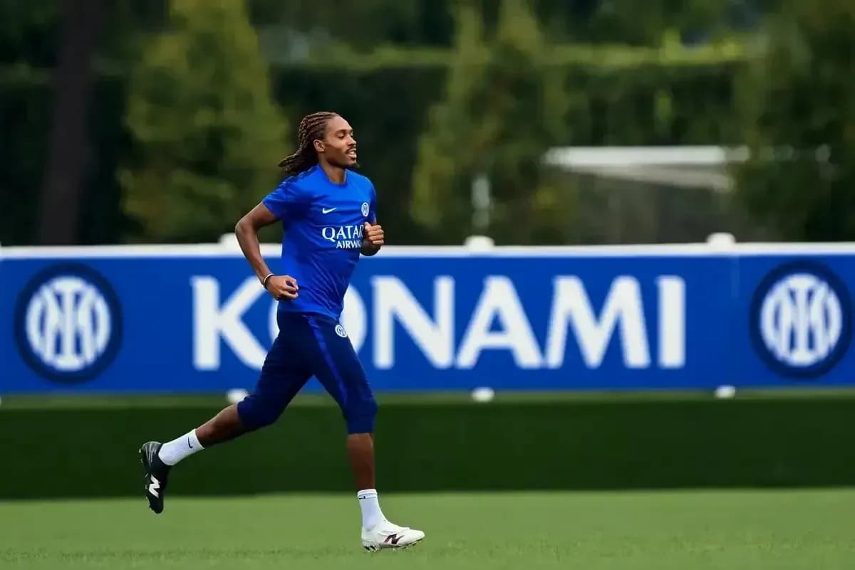 Player jogging on training pitch with team logo backdrop