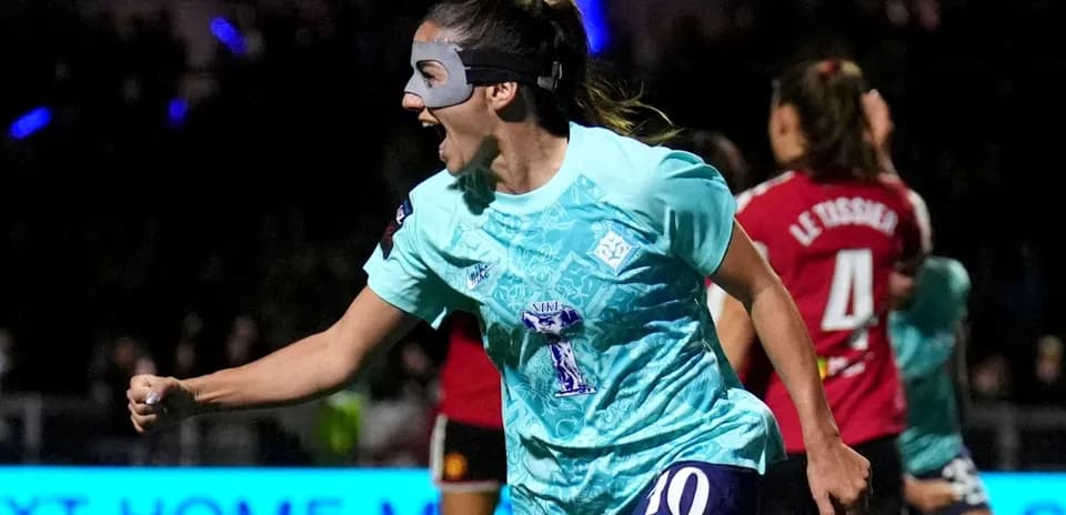 Player celebrating a goal wearing a mask