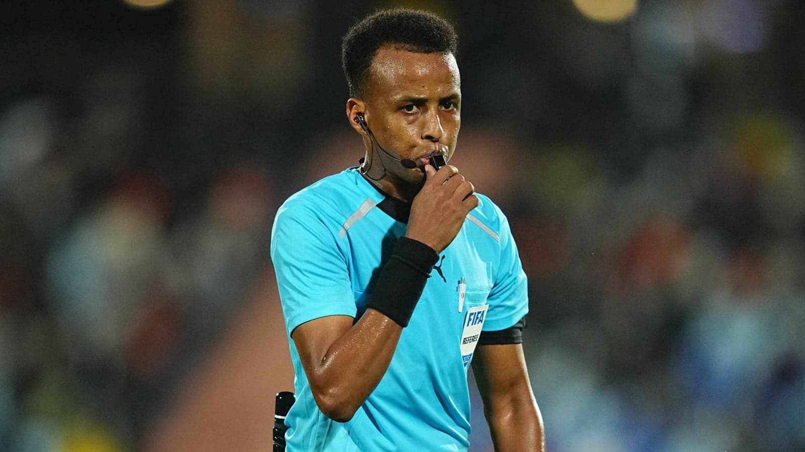 Referee blowing whistle during a football match