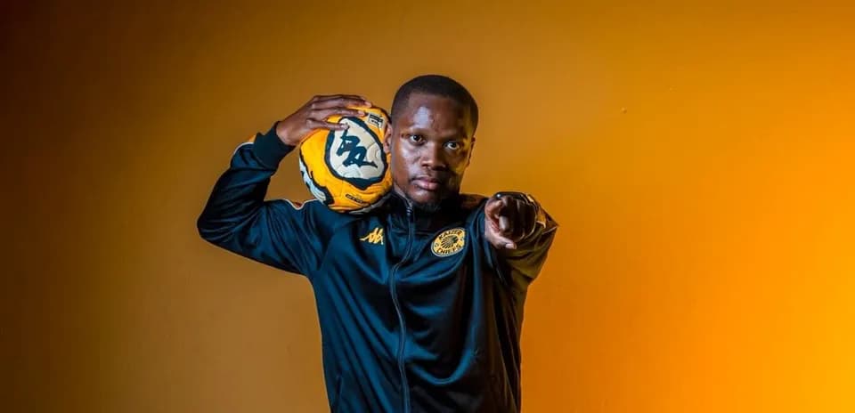 Player pointing while holding a soccer ball