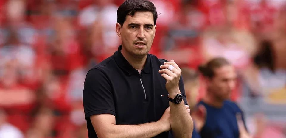 Coach observing match with crossed arms on sidelines