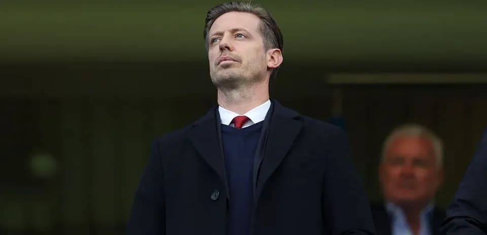 Man in formal attire observing from the stands