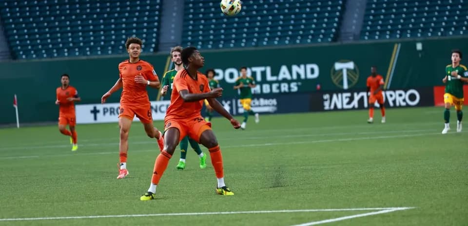 Players competing for the ball during MLS Next Pro match