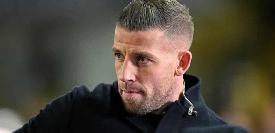 Man with short hair and beard looking thoughtfully