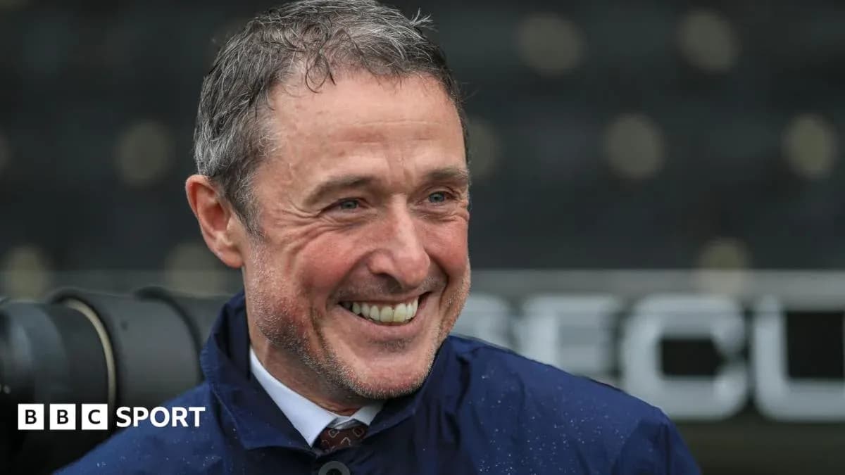 Smiling man in a blue jacket at stadium