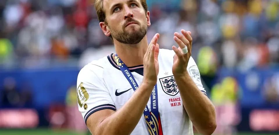 Player wearing medal and applauding on the pitch