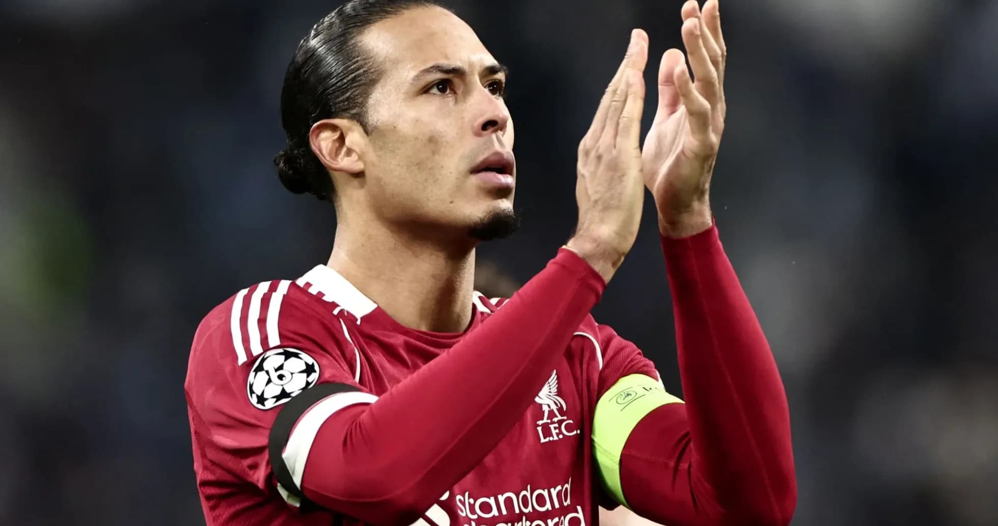 Player applauding fans wearing Liverpool jersey