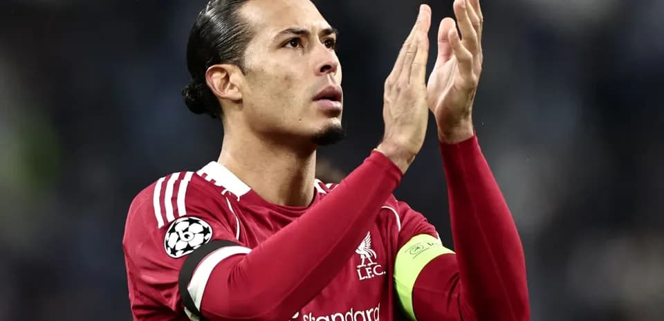 Player applauding fans wearing Liverpool jersey