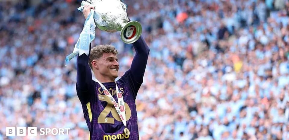 Player celebrating with trophy at stadium
