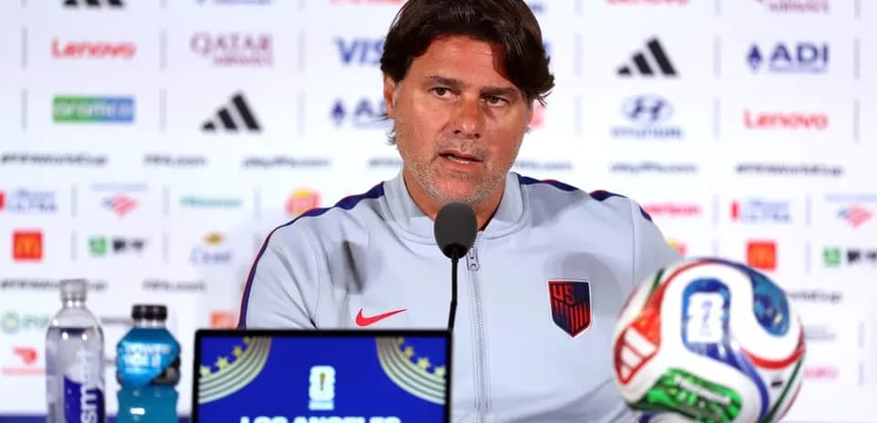 Manager speaking at press conference with soccer ball