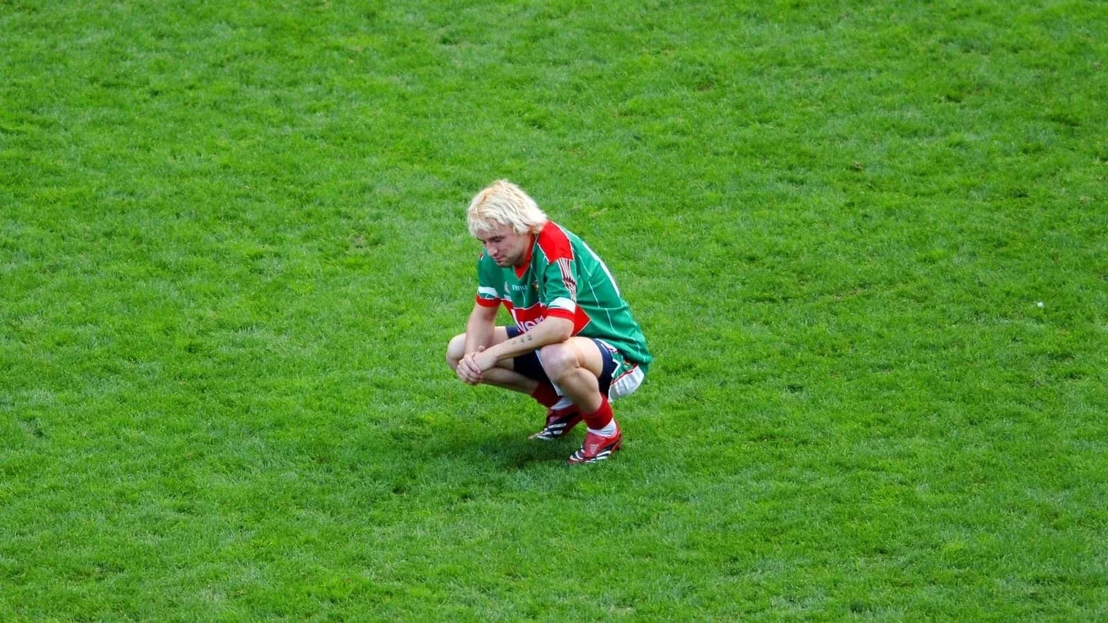 Player squatting on the grass during a match