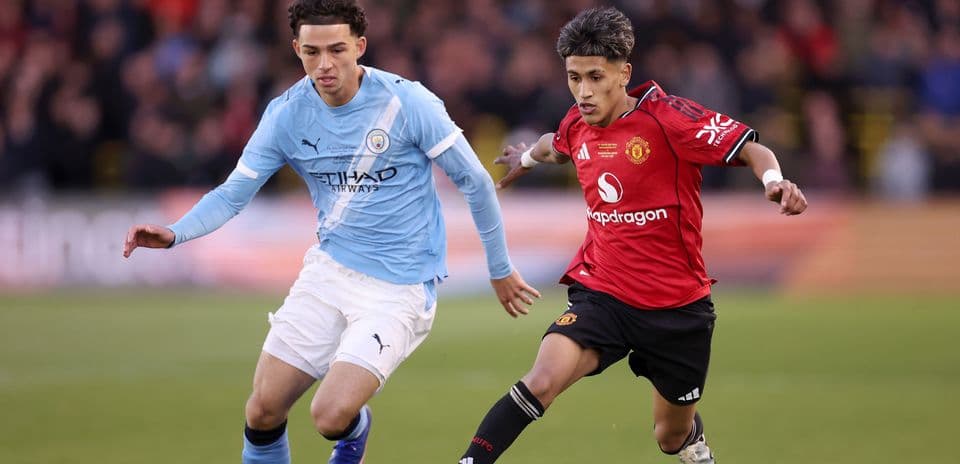 Manchester City and Manchester United players competing for the ball