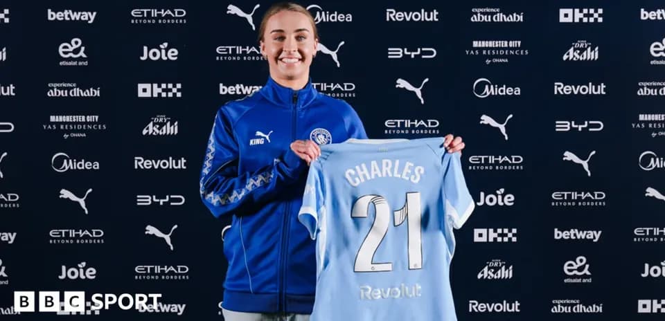 Player holding Manchester City jersey during presentation