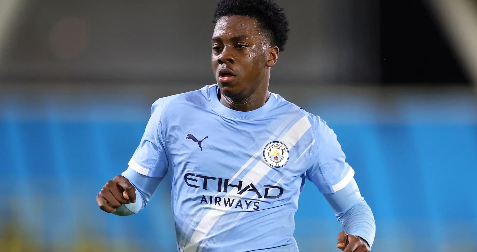 Player running in Manchester City kit during match