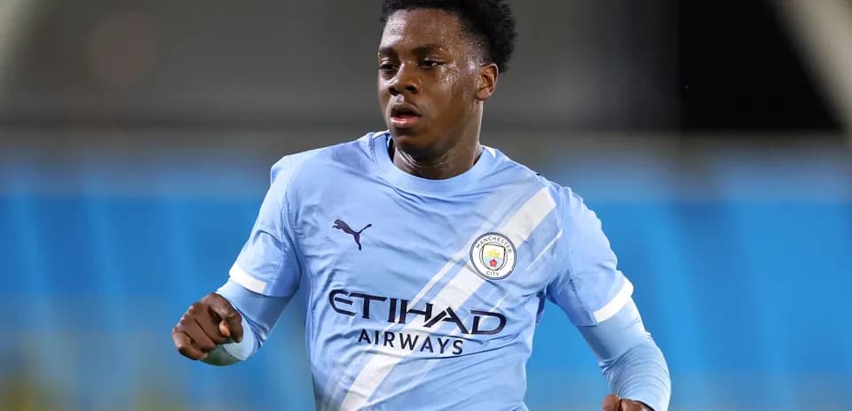 Player running in Manchester City kit during match
