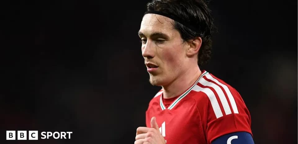 Player in red jersey with captain's armband during match