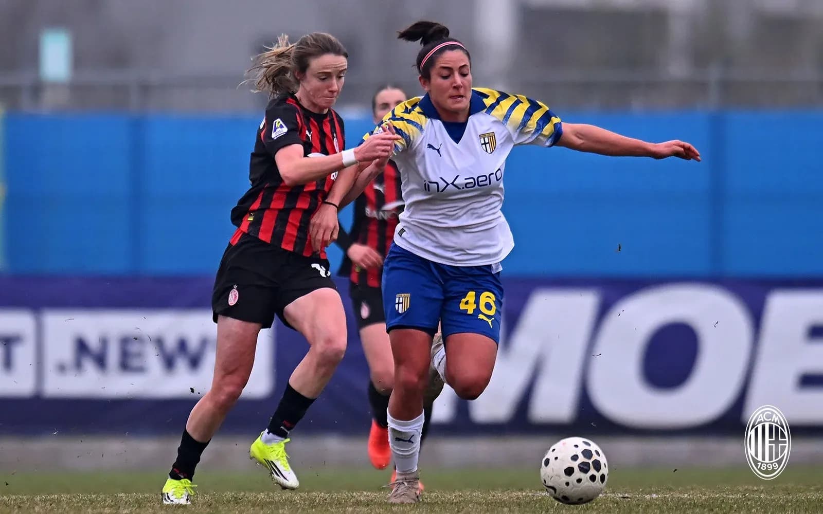AC Milan W player challenges Parma W player for the ball