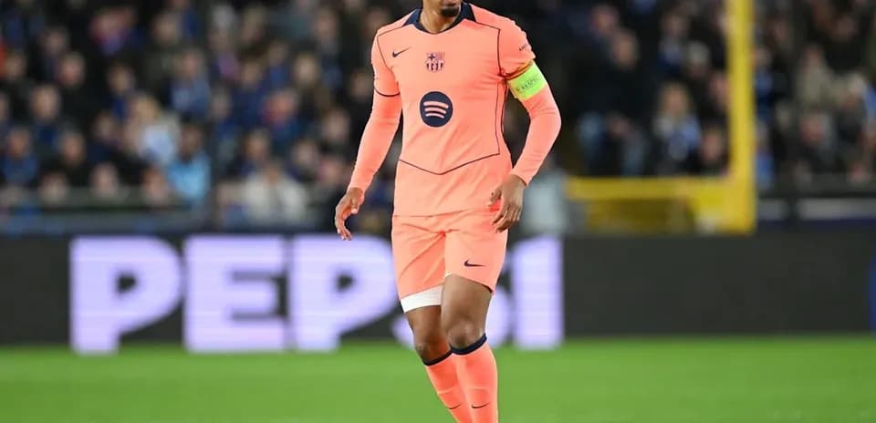 Player in pink jersey with ball on pitch